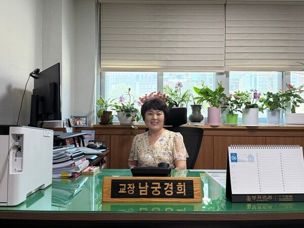 남궁경희 교장선생님이 교장실에서 인터뷰를 마치고 기념 촬영을 하고 있다./사진=이윤 기자