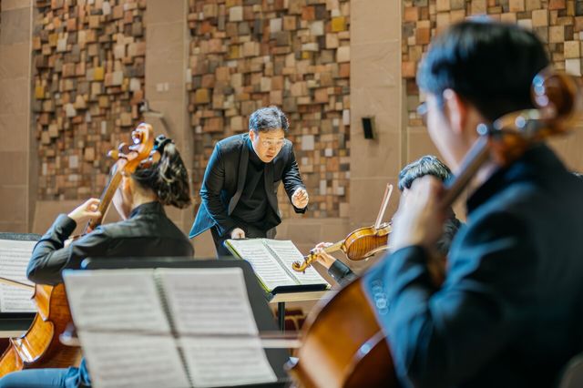 알레그로 오케스트라 단원들이 사이에서 윤염광 감독이 연주를 지휘하는 모습. KB국민카드 제공 [뉴스락]