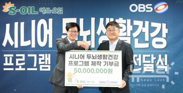 S-OIL 이춘배 부문장(오른쪽)이 25일 두뇌건강 프로그램 제작 기부금 전달식에서 OBS경인TV 김학균 대표(왼쪽)와 기념촬영을 하고 있다. 사진=S-OIL [뉴스락]