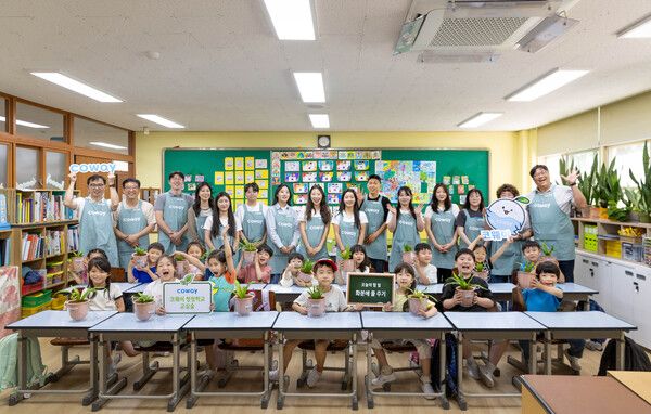 코웨이 임직원 봉사자들과 내발산초등학교 학생들이&nbsp;'청정학교 교실숲 제8호'&nbsp;조성 기념 단체 사진을 찍고 있다. 코웨이 제공 [뉴스락]