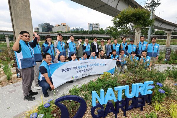봉사활동 참석자들이 '대우건설 Nature' 앞에서 기념촬영을 하고 있다.