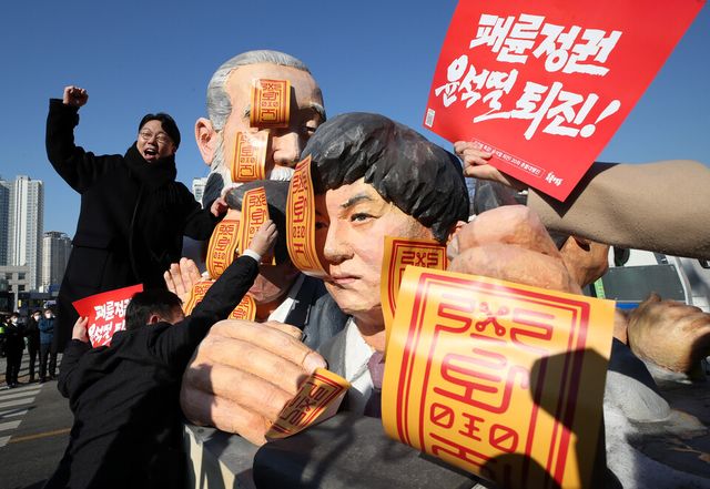 지난 1월 4일 오전 서울 용산구 대통령실 인근에서 촛불승리전환행동(촛불행동) 주최로 열린 ‘윤석열 퇴진-김건희 특검’ 2023 촛불대행진 선포식에서 참석자들이 윤석열 대통령, 한동훈 법무부 장관, 무속인 천공을 형상화한 조형물에 부적을 붙이는 퍼포먼스를 하고 있다. [사진제공=뉴시스]