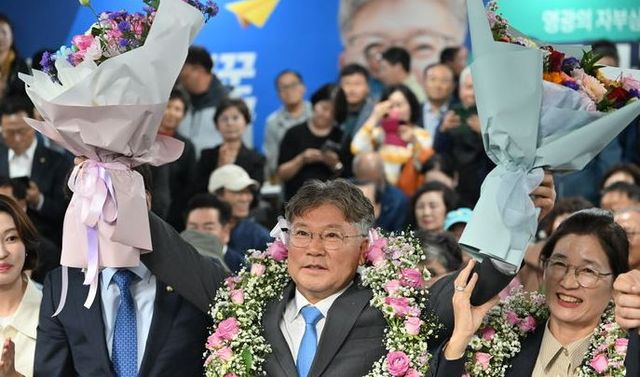 더불어민주당 장세일 영광군수 당선인이 10·16 재·보궐선거가 치러진 16일 오후 전남 영광군 선거사무실에서 당선 확실 소식을 전달받고 꽃다발을 들어보이고 있다.&nbsp;[사진출처=뉴시스]