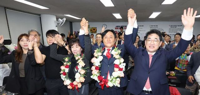 박용철 국민의힘 강화군수 보궐선거 후보가 10·16 재보궐선거가 끝난 16일 오후 인천 강화군 강화읍에 마련된 선거사무소에서 당선이 유력해지자 배준영 국회의원, 가족과 손을 잡고 환호하고 있다.[사진출처=뉴시스]<br>