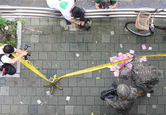 북한이 오물풍선을 살포한 지난 7월 24일 인천 부평구 소재 모 고등학교 인근에서 군 장병들이 풍선에서 떨어진 것으로 추정되는 인쇄물을 확인하고 있다. [사진출처=뉴시스]