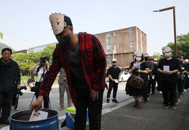 이우영작가사건대책위원회, 한국만화가협회, 한국웹툰작가협회 회원들이 지난해 5월 15일 형설출판사 앞에서 불공정계약 규탄 및 ‘검정고무신’ 장례집회 기자회견을 진행해 팬아트를 태우는 영결 퍼포먼스를 하고 있다. [사진제공=뉴시스]