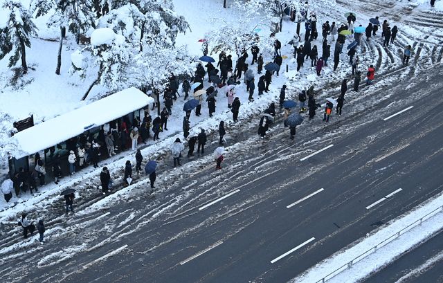 기록적인 폭설이 내린 28일 오전 경기도 수원시 영통구 망포동 한 버스정류장에서 출근길 시민들이 줄지어 서 있다. [사진제공=뉴시스]
