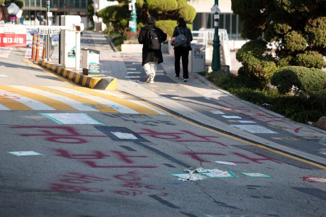 래커칠이 돼 있는 서울 성북구 동덕여대 교내에 학생들이 지나가고 있다. [사진제공=뉴시스]<br>