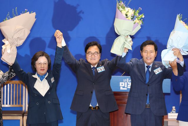 더불어민주당 우원식 의원과 이학영 의원이 지난 16일 오전 서울 여의도 국회 의원회관에서 열린 제22대 국회 전반기 국회의장단 후보 선출 당선자 총회에서 국회의장-부의장 후보로 선출된 뒤 손을 맞잡고 있다. 왼쪽은 추미애 당선자. [사진출처=뉴시스]