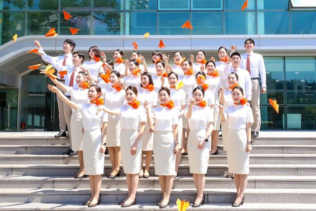 제주항공 신입승무원들이 취항 18주년을 기념해 지난 4일 제주항공 객실훈련센터 앞에서 감귤색 종이비행기를 날리는 세리머니도 진행하고 있다. [사진제공=제주항공]<br>