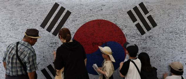 광복절인 지난 15일 오후 서울 서대문구 서대문형무소를 찾은 어린이들이 태극기에 광복을 기념하는 문구를 적고 있다. [사진 출처=뉴시스]<br>