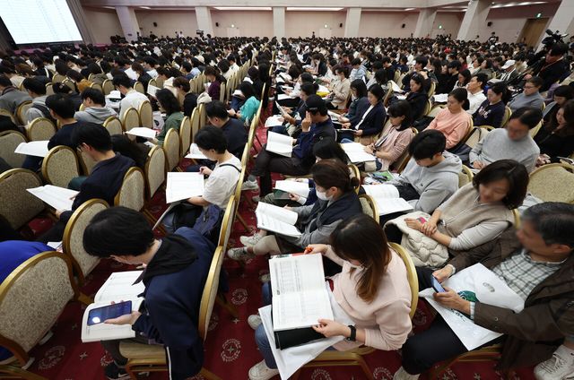 지난해 11월 15일 서울 광진구 세종대 컨벤션센터에서 진행된 ‘종로학원 2025 정시 합격점수 예측 및 전략 설명회’에서 학부모들이 입시 관련 자료를 들여다보고 있다. [사진제공=뉴시스]<br>