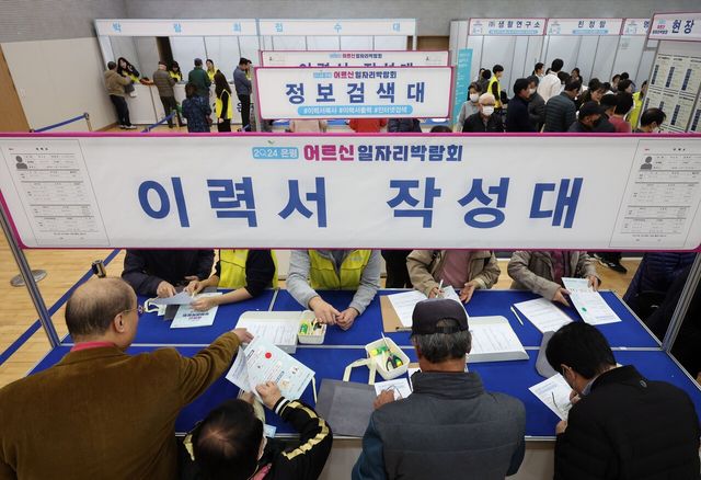 지난해 11월 서울 은평구 은평구청에서 개최된 ‘2024 은평 어르신 일자리 박람회’를 찾은 구직자들이 이력서를 작성대에 모여 있다. [사진제공=뉴시스]<br>