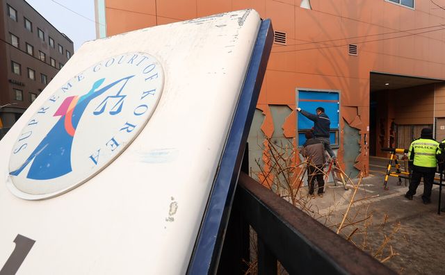 20일 전날 있었던 윤석열 대통령 지지층의 난동으로 파손된 서울 마포구 서울서부지방법원 외벽에서 보수 공사가 이뤄지고 있다. [사진제공=뉴시스]<br>