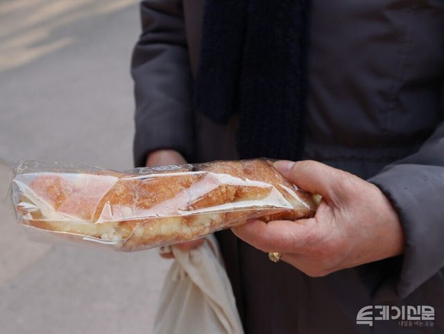 자신의 경험상 복권을 불신한다며 빵을 선택한 시민의 손.&nbsp;ⓒ투데이신문&nbsp;