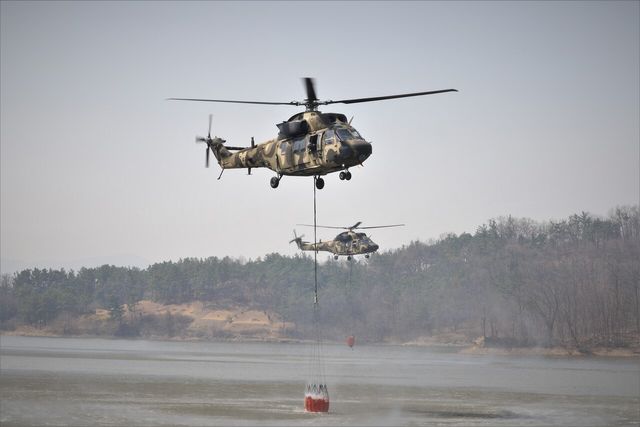 육군 수리온 헬기(KUH-1)가 경북 의성군 안계면 개천저수지에서 밤비바켓(물주머니)에 산불 진화용 물을 급수하고 있다. [사진=육군/뉴시스]