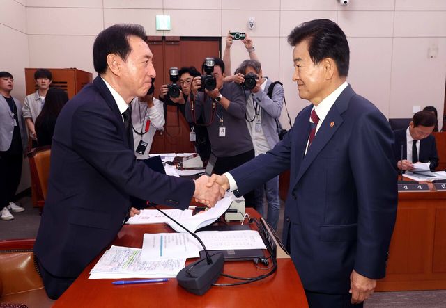 정동영 통일부 장관이 14일 오전 서울 여의도 국회 외교통일위원회에서 열린 통일부 등에 대한 국정감사에서 증인 선서문을 김석기 외통위원장에게 제출하고 악수하고 있다. [사진제공=뉴시스]