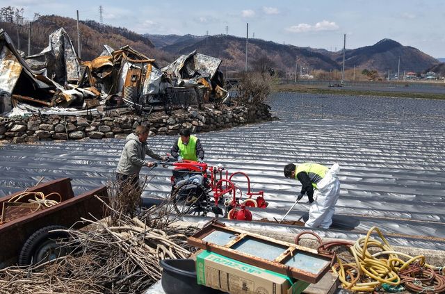 지난 4월 경북 영양군 석보면 화매리 한 농가에서 산불 피해를 입은 농민과 농촌진흥청 농업기계 안전전문관들이 농기계로 밭을 일구고 있다. [사진제공=뉴시스]