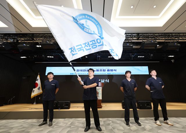 지난달 14일 서울 용산구 대한의사협회에서 열린 전국전공의노동조합 출범식에서 초대위원장으로 선출된 유청준 노조 위원장이 노조깃발을 흔들고 있다. [사진제공=뉴시스]