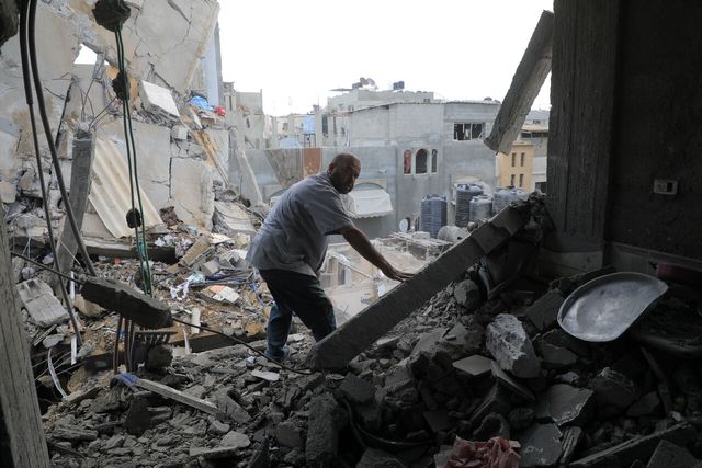 지난해 5월 가자지구 남부 라파에서 한 주민이 이스라엘의 공습으로 파괴된 건물 잔해를 살펴보고 있다. [사진=뉴시스]