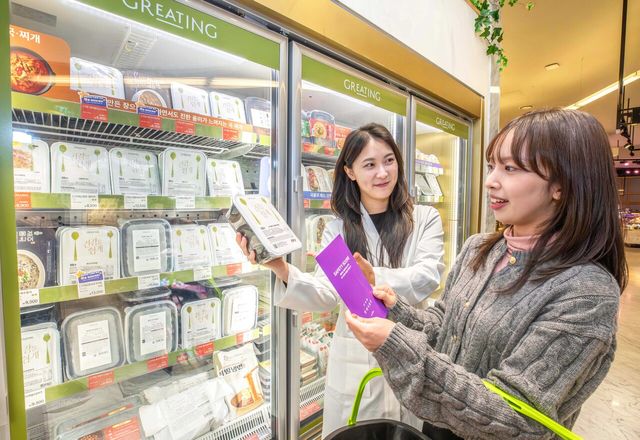 경기 성남시에 위치한 현대백화점 판교점 지하1층 현대식품관에서 현대그린푸드 영양사가 '세이프티 스코어'가 적용된 가공식품을 고객에게 안내해주고 있는 모습. [사진=현대백화점그룹]