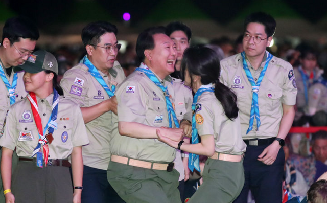 윤석열 전 대통령이 지난 2023년 8월 2일 전북 부안군 새만금 일대에서 열린 2023 새만금 제25회 세계스카우트잼버리 개영식에서 6개국 스카우트 대원 선서 때 일어나며 부인 김건희 여상의 도움을 받고 있다. [사진제공=뉴시스]