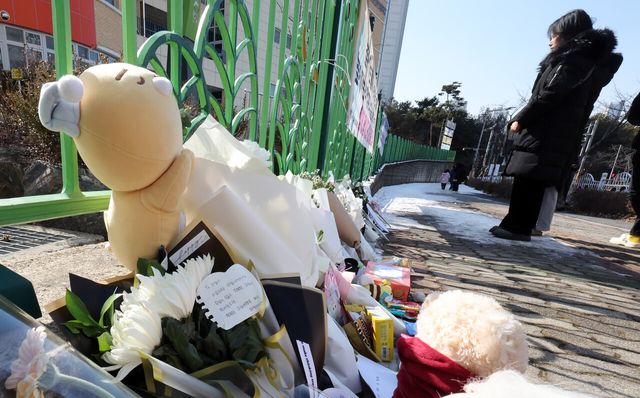 지난 11일 초등학생 피살사건이 발생한 대전 서구 관저동 소재 모 초등학교 정문 옆 담장에서 추모하기 위해 방문한 시민들이 국화꽃 등을 놔둔 모습. [사진제공=뉴시스]<br>