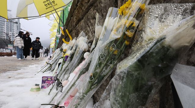 지난 12일 초등학생 피살 사건이 일어난 대전 서구 관저동 소재 모 초등학교 담장에 고 김하늘양을 추모하는 문구와 국화가 놓여져 있다. [사진제공=뉴시스]<br>
