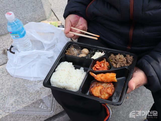 날씨 좋은 날 탑골공원에서 어르신이 갓 받은 무료도시락을 맛보고 있다. ⓒ투데이신문<br>
