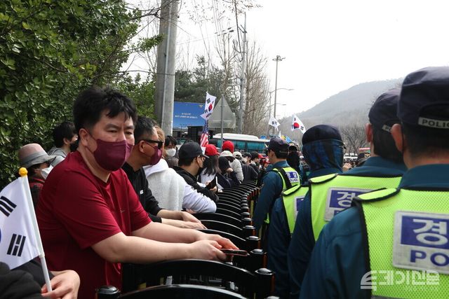 탄핵에 반대하는 윤 대통령 지지자들이 경찰의 바리케이드를 앞에 두고 태극기를 흔들고 있다. ⓒ투데이신문