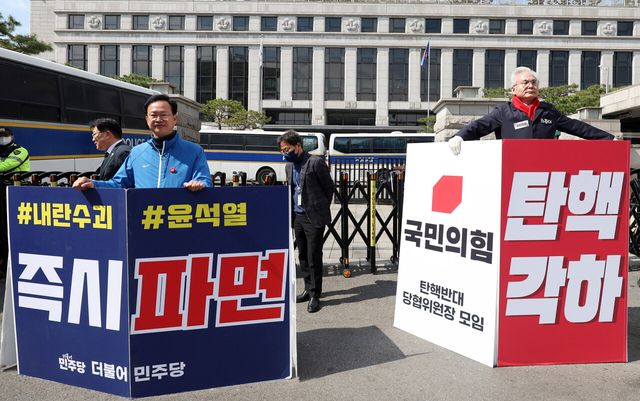 윤석열 대통령에 대한 탄핵심판 선고가 지연되고 있는 28일 오전 서울 종로구 헌법재판소 앞에서 더불어민주당 송재봉(왼쪽) 의원이 윤 대통령 파면을, 국민의힘 하종대 부천시병 당협위원장이 탄핵 각하를 각각 촉구하는 1인시위를 하고 있는 모습. [사진제공=뉴시스]<br>
