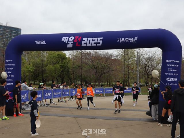 마라톤 코스를 완주한 참가자들이 도착 지점을 통과하고 있다. ⓒ투데이신문