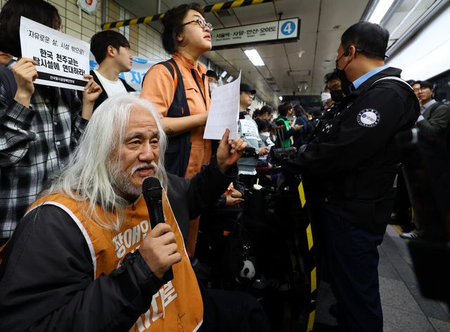 전장연의 출근길 지하철 탑승 시위가 1년여 만에 다시 진행된 지난 21일 서울 지하철 4호선 혜화역에서 전장연 박경석 대표 등 참가자들이 선전전을 이어가고 있다. [사진제공=뉴시스]<br>