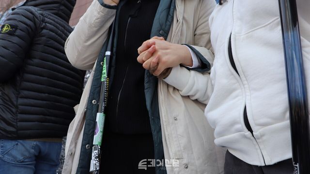 윤석열 대통령 탄핵 심판 선고를 약 5분 남기고 주아(가명·20)와 바둑이(가명·23)가 손을 잡고 있다. ⓒ투데이신문<br>
