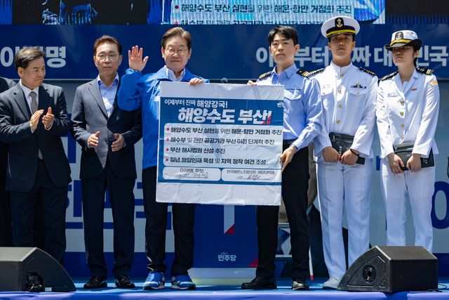 이재명 더불어민주당 대선 후보가 14일부산 부산진구 서면 젊음의 거리에서 열린 유세에서 권기흥 에이치라인해운해상직원노조 위원장과 해양수도 부산 협약서에 서명한 뒤 기념촬영을 하고 있다. [사진=공동취재단/뉴시스]