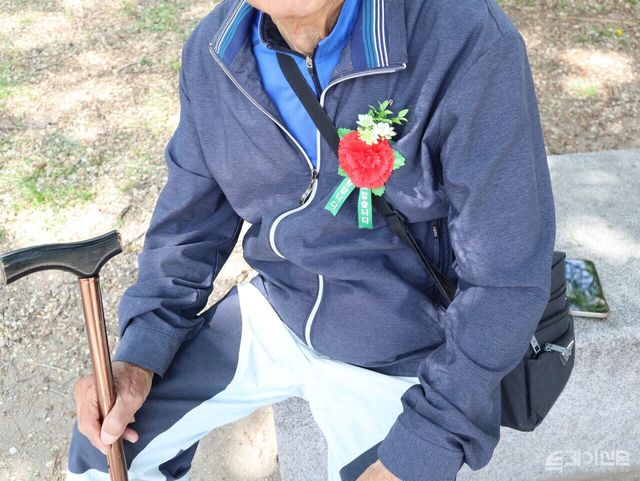가슴에 카네이션을 단 채 벤치에 앉아 햇살을 맞고 있는 최씨(90세)가 쉬고 있다. ⓒ투데이신문