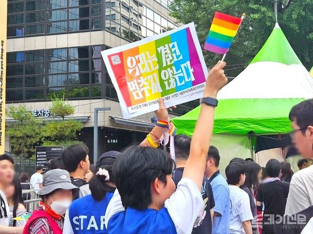 14일 오후 2025 서울 퀴어 문화축제 운영진이 무지개색 깃발을 높이 들어 올리고 있다. ⓒ투데이신문