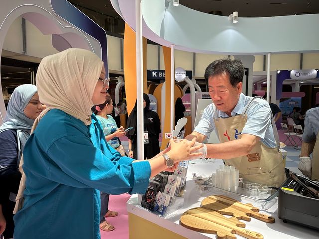 민경천 한우자조금관리위원장이 말레이시아 쿠알라룸푸르 원우타마 쇼핑센터에서 열린 ‘2025 K-관광로드쇼’ 한우 홍보 부스에서 방문객들에게 한우 불고기를 건네고 있다. [사진제공=한우자조금관리위원회]