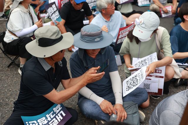 30일 서울 용산 대통령실 인근의 지하철 삼각지역 앞에서 열린 송미령 유임 철회 내란농정 즉각 청산 1차 전국농민결의대회에 참석한 한 농민이 동덕여대 총장직선제 의무화 청원에 참여하고 있다. ⓒ투데이신문