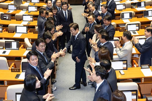 이재명 대통령이 지난 26일 서울 여의도 국회 본회의장에서 추가경정예산(추경) 시정연설을 하기 위해 이동하며 더불어민주당 의원들과 악수를 하고 있는 모습. [사진제공=뉴시스]<br>
