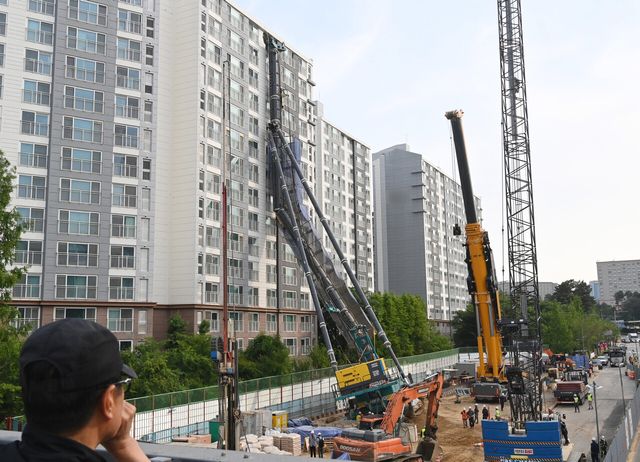 6일 경기 용인시 기흥구 서천동 인덕원~동탄 복선전철 공사 현장에서 중장비인 천공기(지반을 뚫는 건설기계)가 15층 높이 아파트 벽면에 기댄 모습으로 쓰러져 있다. [사진=뉴시스]