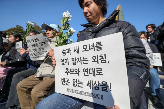 지난해 2월 대한불교조계종 사회노동위원회와 기초법바로세우기공동행동 등 관계자들이 서울 용산구 대통령실 앞에서 송파 세 모녀 10주기 추모제에서 손피켓을 들고 있다. [사진제공=뉴시스]
