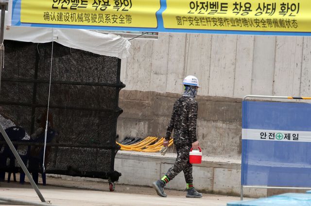 지난 8일 서울 성북구 소재 한 주택정비사업 건설현장에서 근로자가 음료를 든 채 걸음을 옮기고 있다. [사진제공=뉴시스]