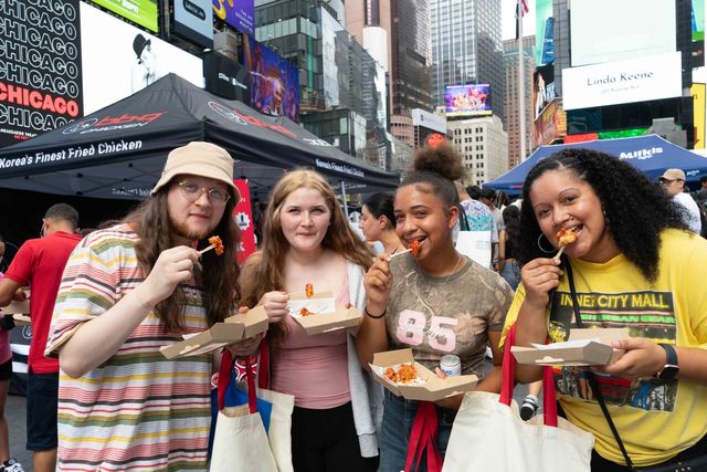 BBQ양념치킨과 밀키스를 맛보고 있는 뉴욕 시민들. [사진=제너시스BBQ]