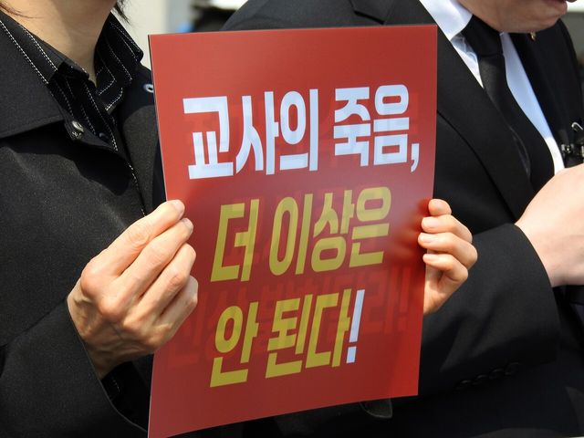 한국교원단체총연합회 관계자가 지난 5월 27일 제주도교육청 교권 보호 대책 촉구 기자회견에서 교권 회복을 촉구하는 손피켓을 들고 있다. [사진제공=뉴시스]