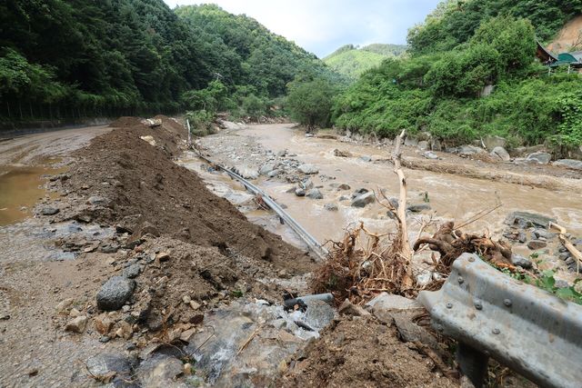 지난 20일 경기 가평군 마일리 일대에 내린 극한호우로 인해 산사태가 발생해 도로가 유실된 모습. [사진제공=뉴시스]