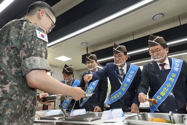 노동진 수협중앙회장(사진 오른쪽 두번째)이 9일 육군 7군단에서 군 장병에게 수산물 특식을 제공하는 '우리 수산물 DAY'에서 완성된 요리를 직접 배식하고 있다. [사진=수협중앙회]<br>