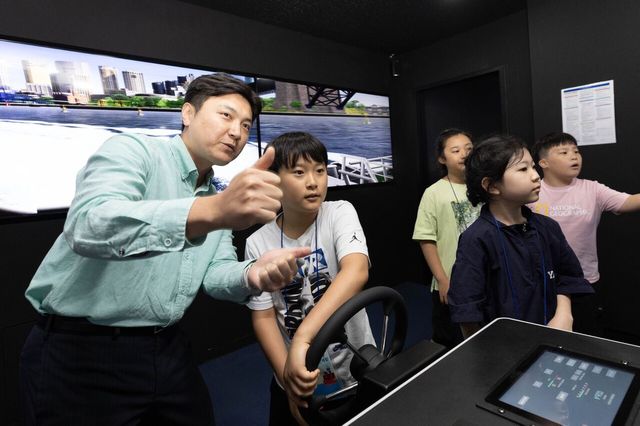 상선체험 활동에 참여한 어린이들이 13일 HMM오션서비스 트레이닝센터에서 선박 조종 시뮬레이션을 체험하고 있다. [사진=HMM]