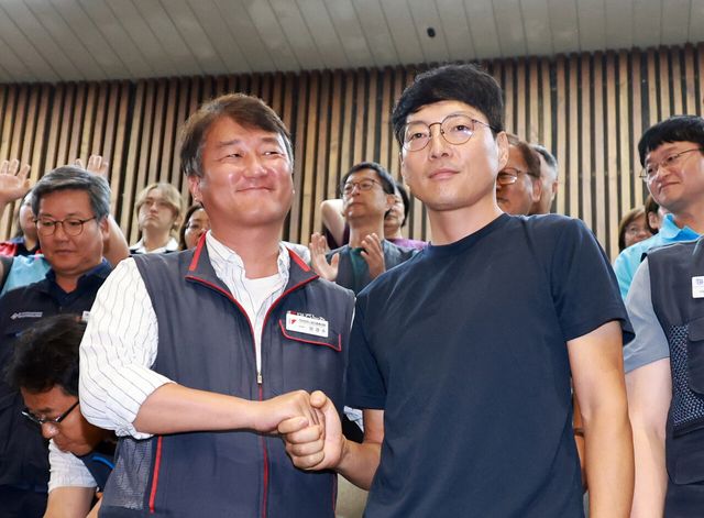  전국민주노동조합총연맹 양경수 위원장과 거제통영고성 조선하청지회 유최안 조합원이 지난 24일 오전 서울 여의도 국회에서 열린 제428회 국회(임시회) 제2차 본회의에서 노란봉투법이 더불어민주당 주도로 통과되자 기뻐하며 손을 맞잡고 있다. [사진제공=뉴시스]