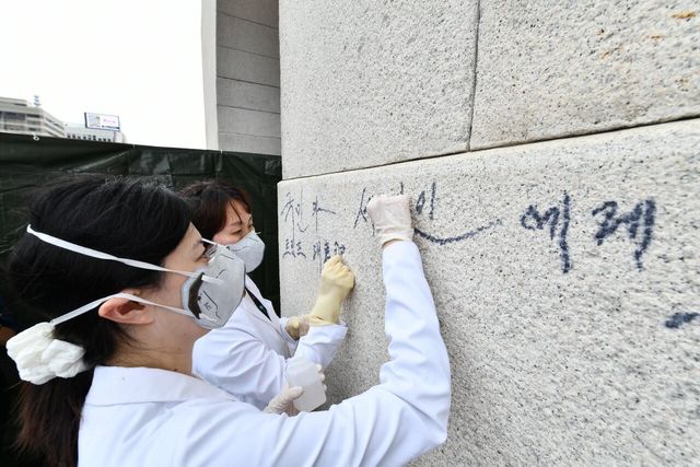 지난 8월 국가유산청 국립고궁박물관 관계자들이 낙서로 훼손된 서울 종로구 경복궁 광화문 석축의 긴급 복구 작업을 진행하고 있다. [사진제공=국가유산청]